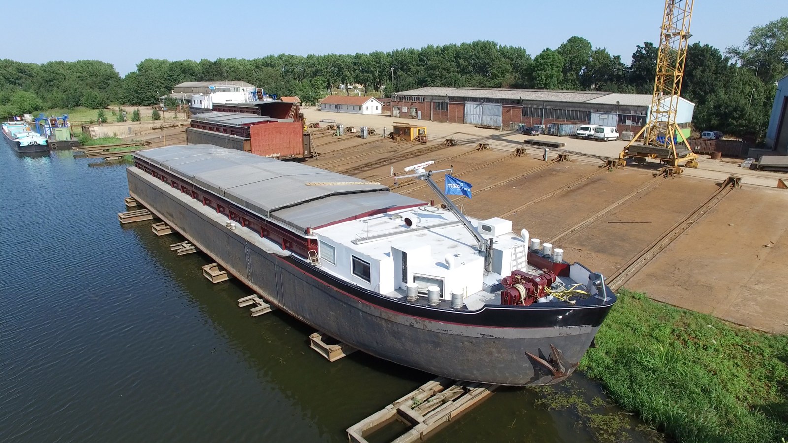 Binnenvaartschip op de helling van de scheepswerf in Maasbracht, vanuit de lucht